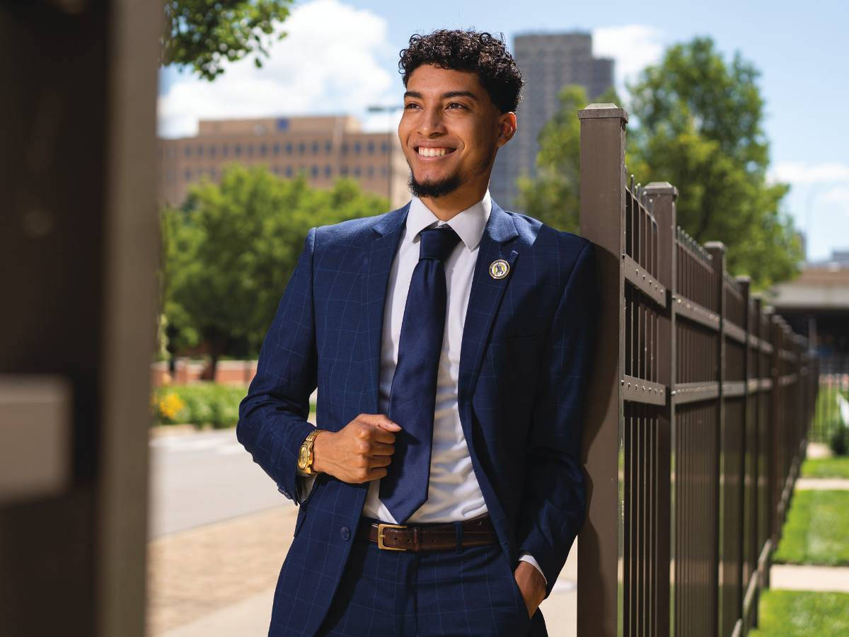 man in blue suit smiling outside